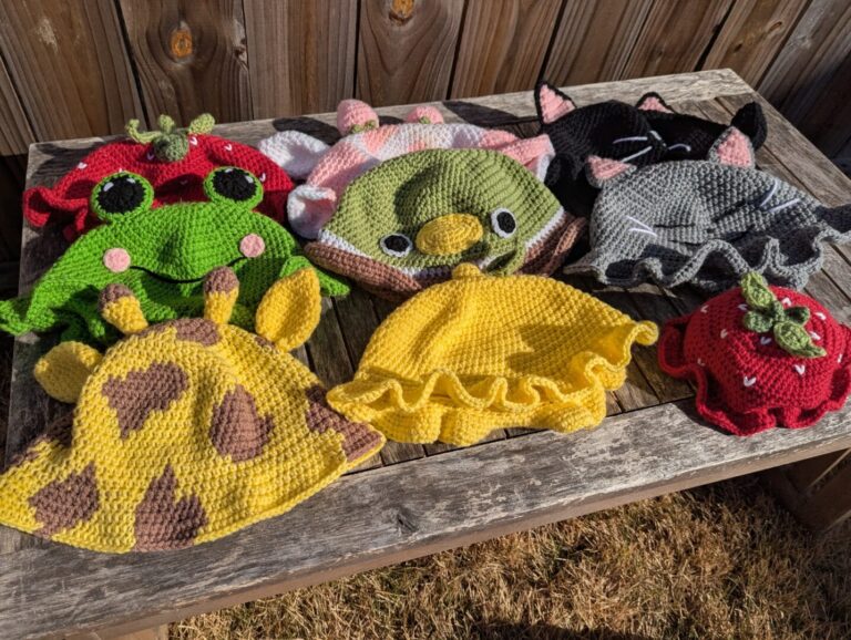 Crocheted bucket hats laid out on a wooden table